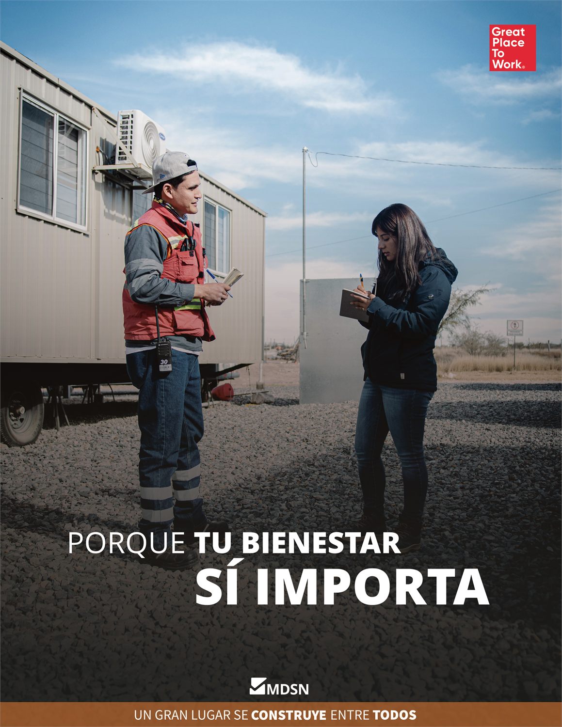 Cartel de la campaña «Porque tu bienestar sí importa» de Minas de San Nicolás: dos trabajadores conversando junto a las oficinas de obra