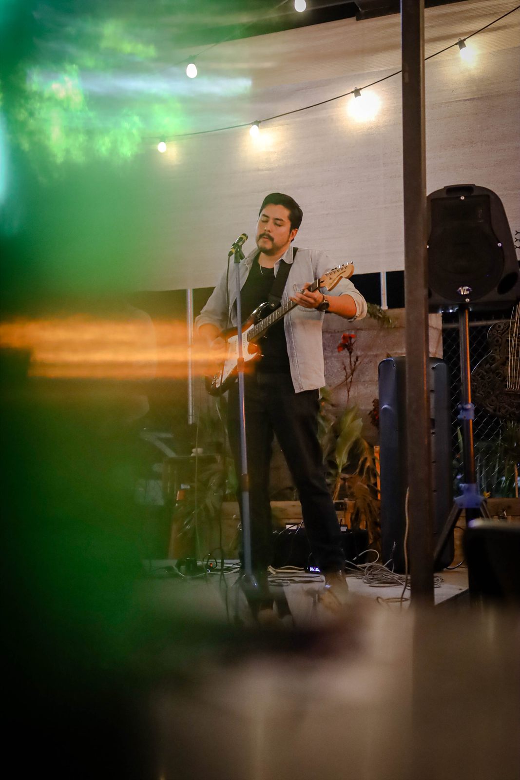 Presentación en vivo en un escenario al aire libre, bajo luces cálidas