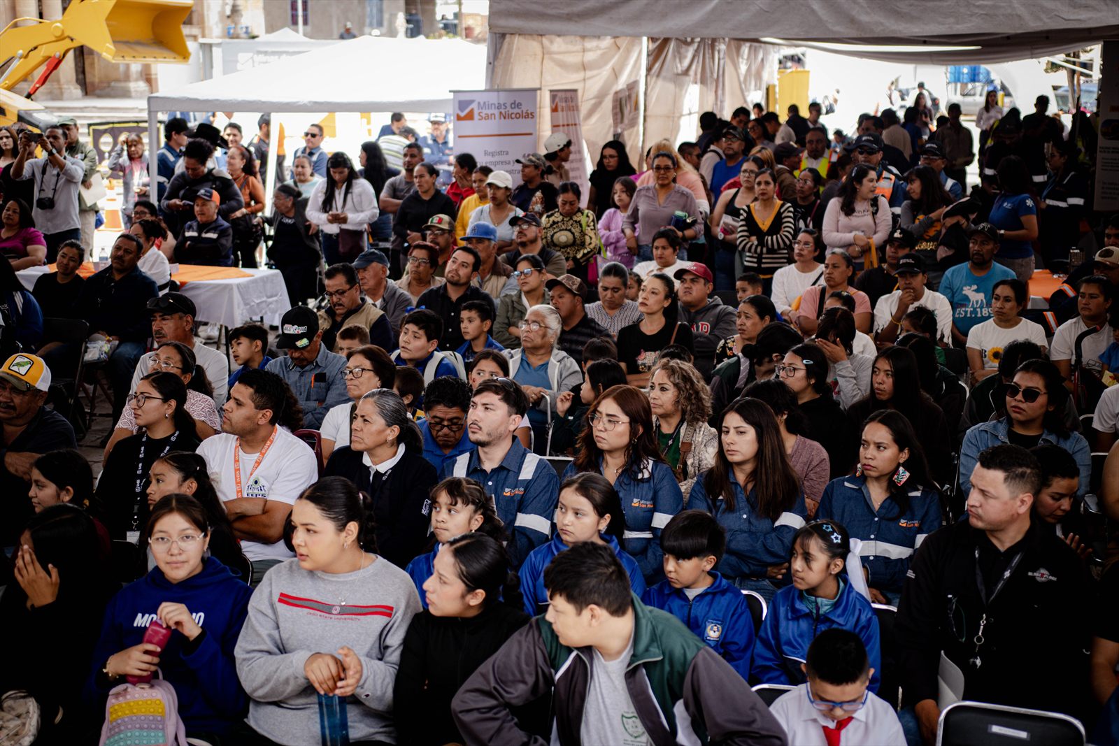 Público sentado durante una actividad de la Expo Minería, con el estand de Minas de San Nicolás al fondo