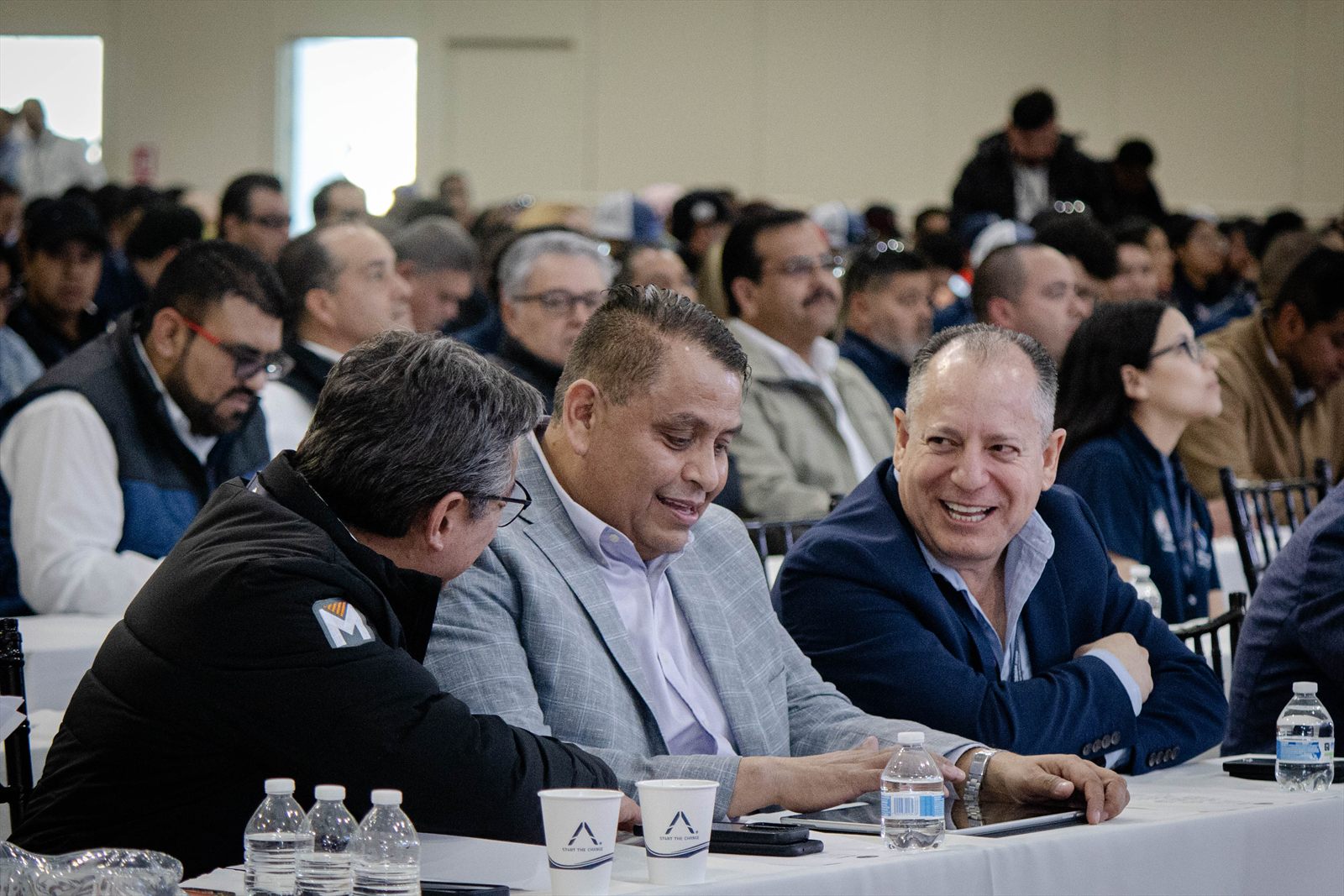 Asistentes conversando entre risas en una mesa del evento