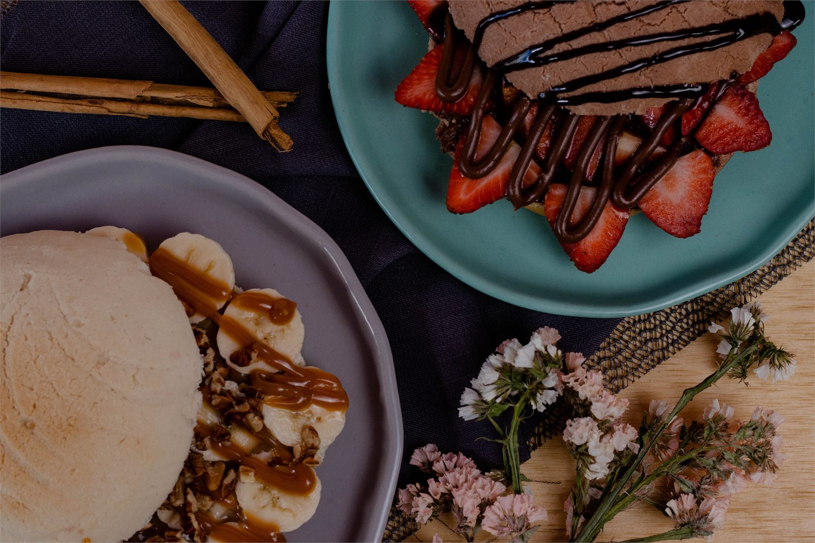 Pan dulce con fresas y chocolate sobre mesa decorada con flores, vista cenital
