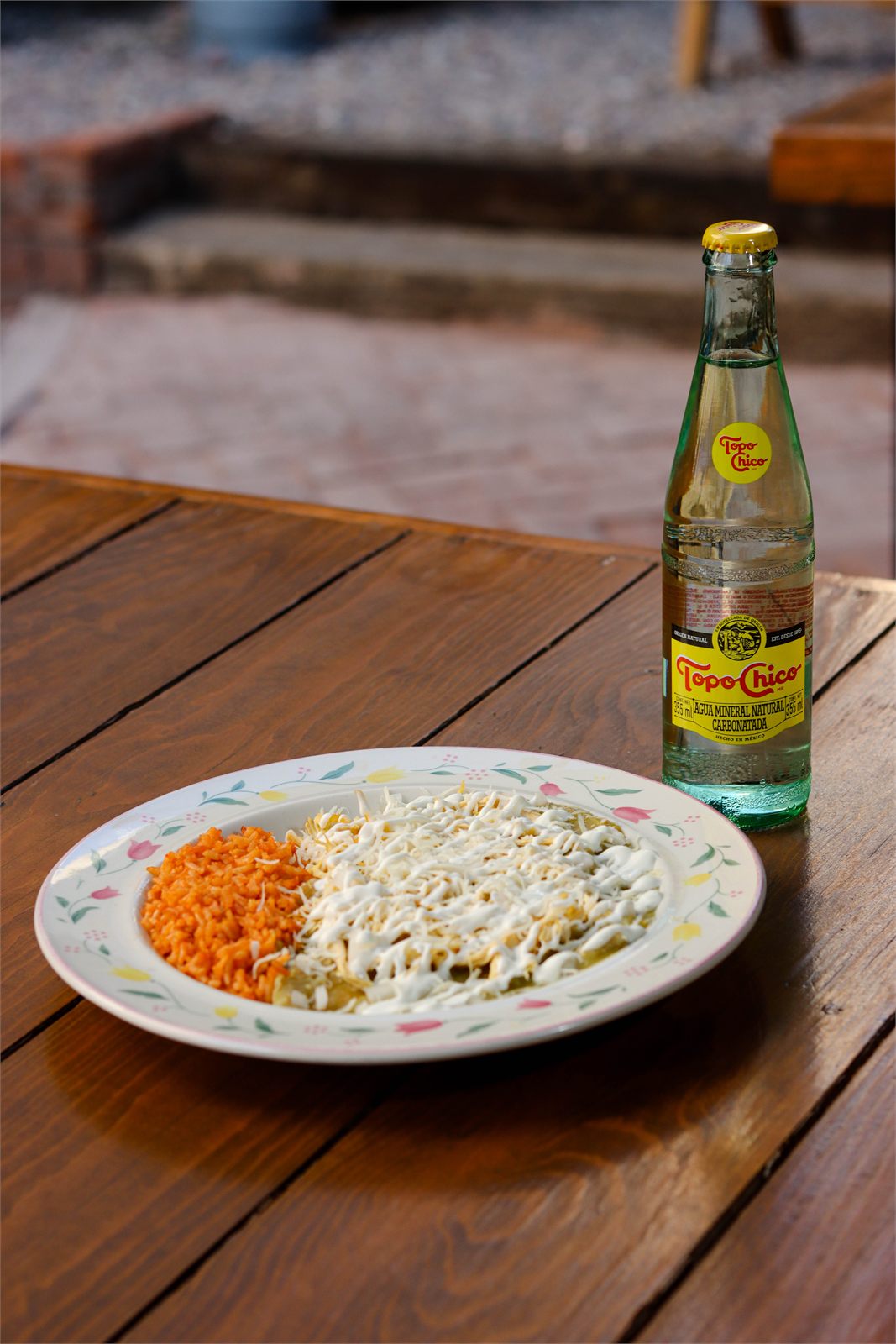 Platillo con arroz y bebida embotellada sobre mesa de madera