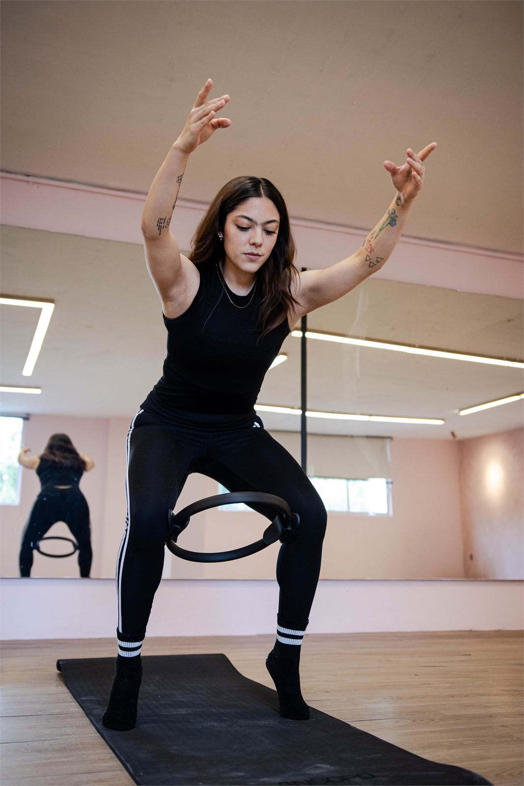 Ejercicio con aro de pilates frente al espejo del estudio MILA
