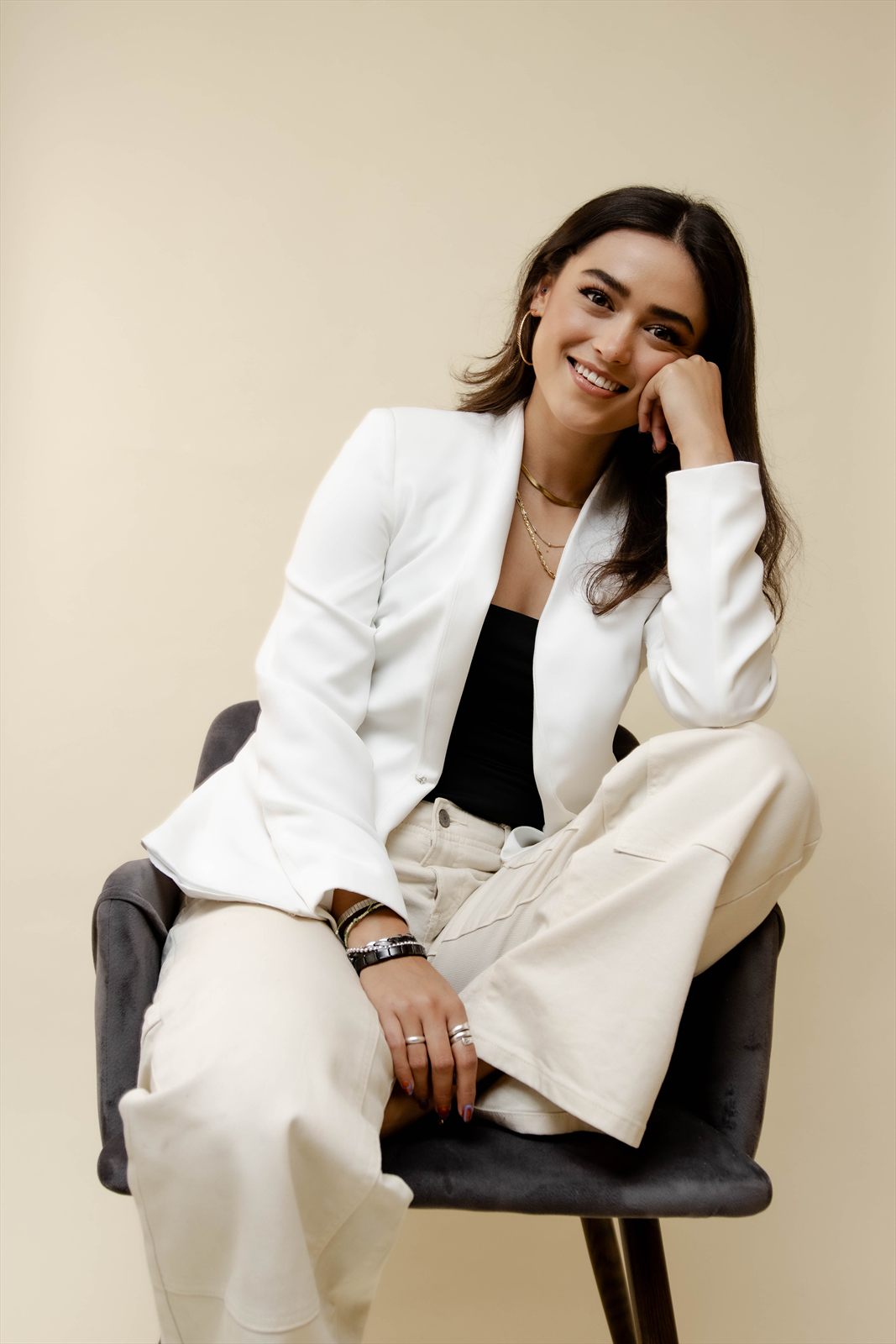 Retrato sentado en una silla del estudio, en traje blanco